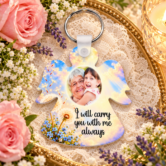 Memorial angel photo keyring with dandelion and forget-me-not artwork displayed on lace beside pink roses and candle