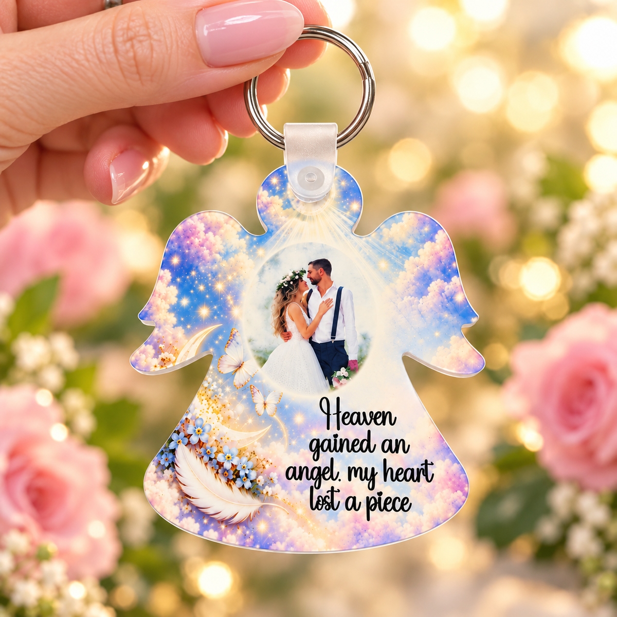 Heaven Gained an Angel personalised photo keyring held in hand against pink roses and warm fairy lights