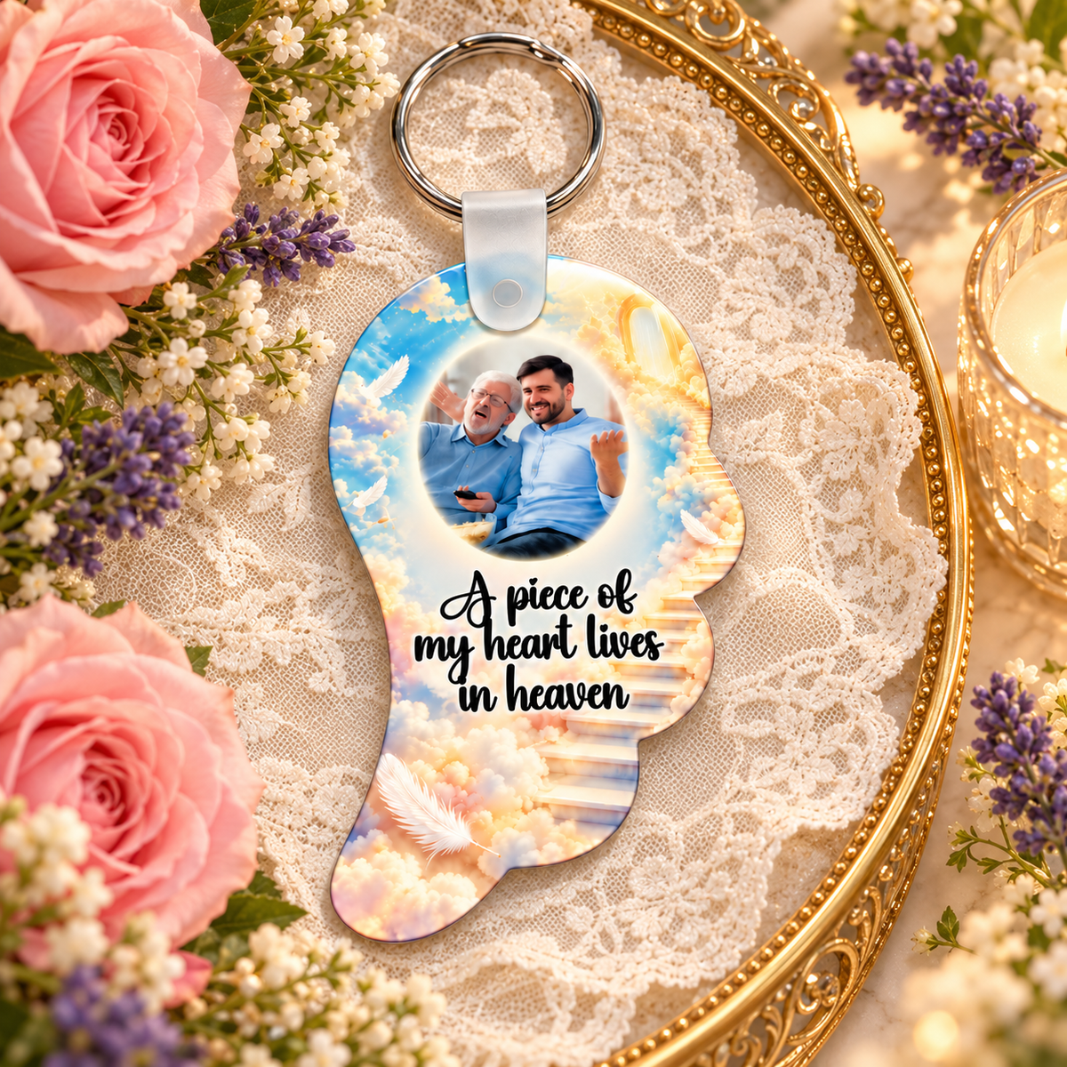 Memorial angel wing keyring with staircase to heaven design displayed on a gold tray with lace, flowers and candlelight