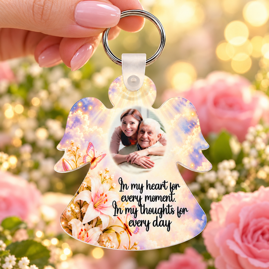 Memorial angel photo keyring held in hand with soft golden clouds and In my heart for every moment wording