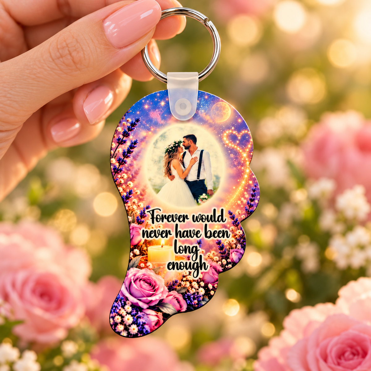 Personalised purple and pink memorial angel wing photo keyring held against a soft rose background