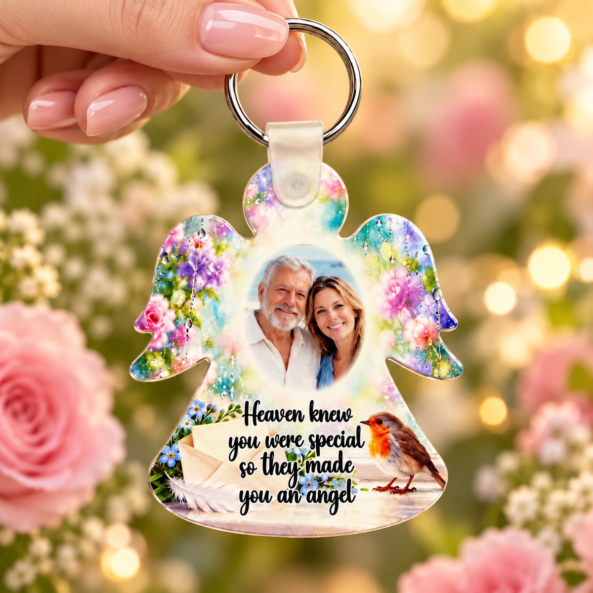 Personalised robin memorial angel keyring held in hand with loved one's photograph, colourful flowers and Heaven knew you were special verse