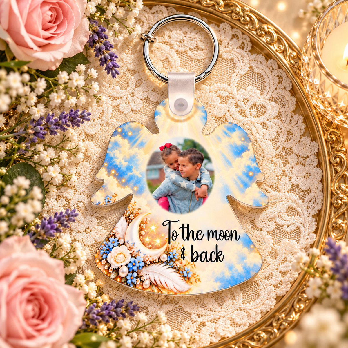 To the Moon and Back angel-shaped photo keyring displayed on a gold tray with lace, pink roses and lavender