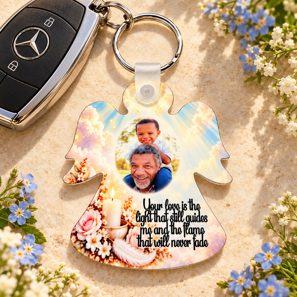 Personalised remembrance angel keyring beside car keys and blue flowers, featuring a memorial candle, white feather and photo