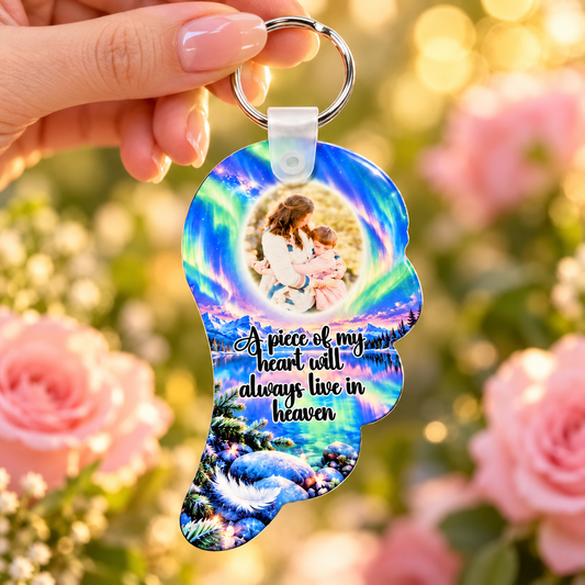 Colourful northern lights angel wing photo keyring held in hand against soft pink roses